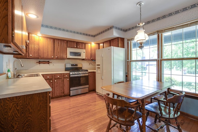400 Seafarer Dr, Third Lake, IL 60030 - kitchen featuring white appliances, light wood finished floors, brown cabinets, light countertops, and decorative light fixtures