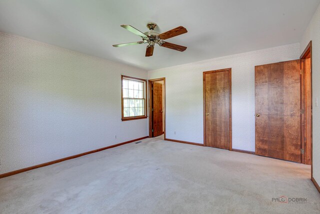 400 Seafarer Dr, Third Lake, IL 60030 - unfurnished bedroom with ornamental molding, light carpet, a ceiling fan, and two closets