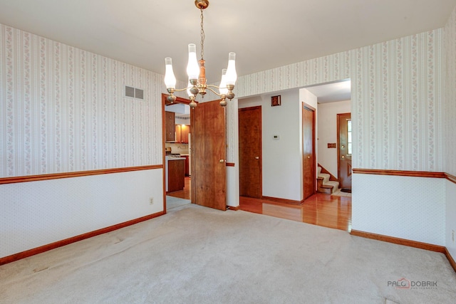 400 Seafarer Dr, Third Lake, IL 60030 - empty room featuring a chandelier, carpet flooring, stairs, and wallpapered walls