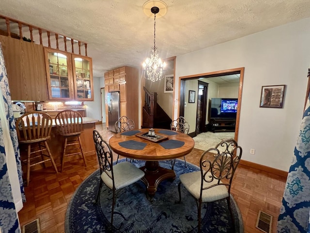 205 E St, Penfield, IL 61862 - dining area with a textured ceiling, stairs, and a chandelier