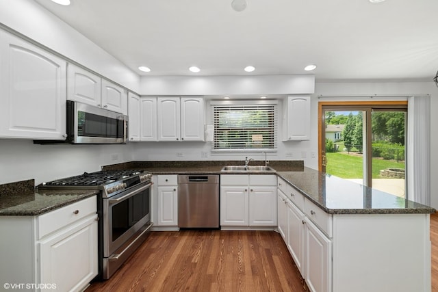 600 N Brookdale Dr, Schaumburg, IL 60194 - kitchen with stainless steel appliances, a peninsula, dark stone counters, white cabinetry, and recessed lighting