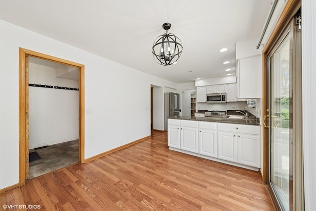 600 N Brookdale Dr, Schaumburg, IL 60194 - kitchen with stainless steel appliances, dark countertops, a chandelier, white cabinets, and a peninsula
