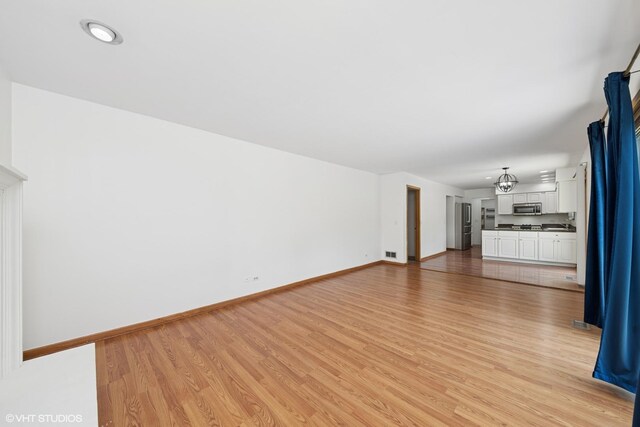 600 N Brookdale Dr, Schaumburg, IL 60194 - unfurnished living room featuring light wood finished floors and baseboards
