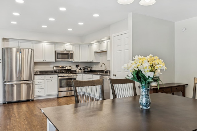 5618 Marietta Dr, Crystal Lake, IL 60014 - kitchen with stainless steel appliances, dark countertops, dark wood finished floors, recessed lighting, and white cabinetry