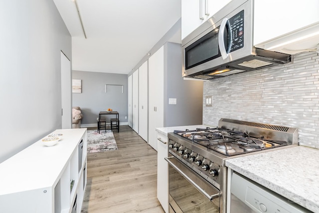 21 W Chestnut St Unit 907, Chicago, IL 60610 - kitchen featuring appliances with stainless steel finishes, light countertops, backsplash, and light wood-style floors