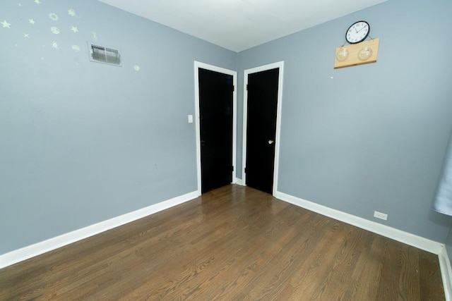 empty room featuring wood finished floors and baseboards