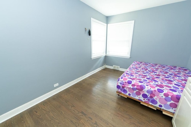 bedroom featuring dark wood-type flooring and baseboards