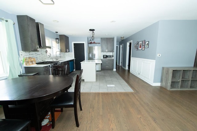 dining room with light wood-style floors and wainscoting