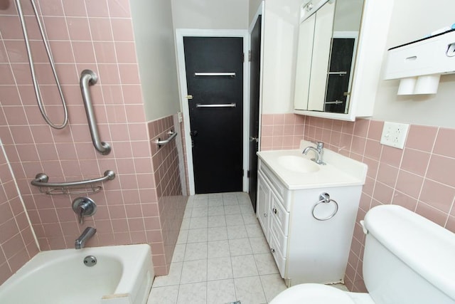 bathroom featuring tile walls, vanity, tub / shower combination, tile patterned floors, and wainscoting