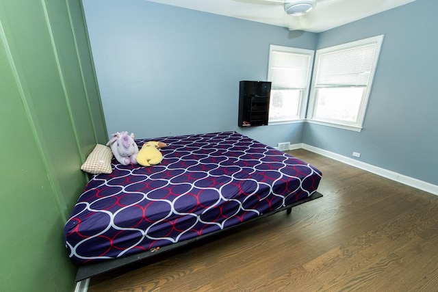 bedroom with wood finished floors and baseboards
