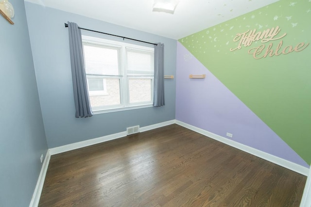 spare room featuring wood finished floors and baseboards