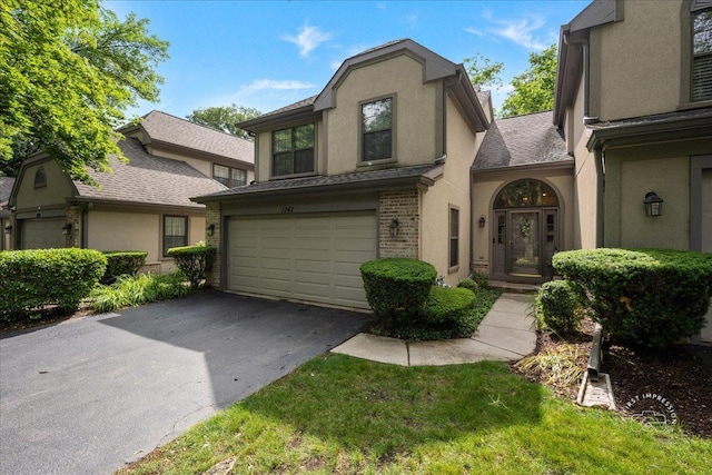1242 Hobson Oaks Dr, Naperville, IL 60540 - view of front facade featuring a garage, stucco siding, asphalt driveway, brick siding, and roof with shingles