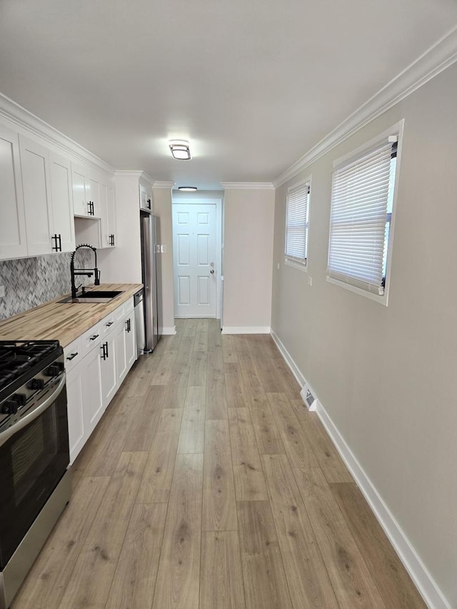16536 Wolcott Ave, Markham, IL 60428 - kitchen featuring stainless steel appliances, white cabinetry, backsplash, light wood-type flooring, and ornamental molding