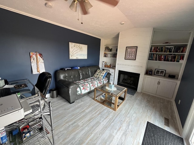 18367 US-150 Hwy, Bloomington, IL 61705 - living room with lofted ceiling, a textured ceiling, a ceiling fan, wood finished floors, and built in shelves