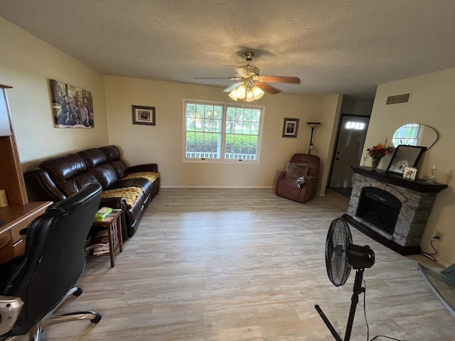 18367 US-150 Hwy, Bloomington, IL 61705 - living area with ceiling fan, light wood-style flooring, a textured ceiling, and a fireplace