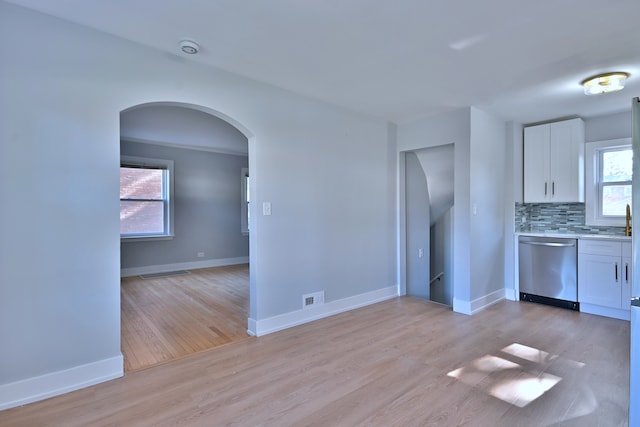 2024 S 24th Ave, Broadview, IL 60155 - kitchen with dishwasher, arched walkways, light wood finished floors, white cabinets, and light countertops