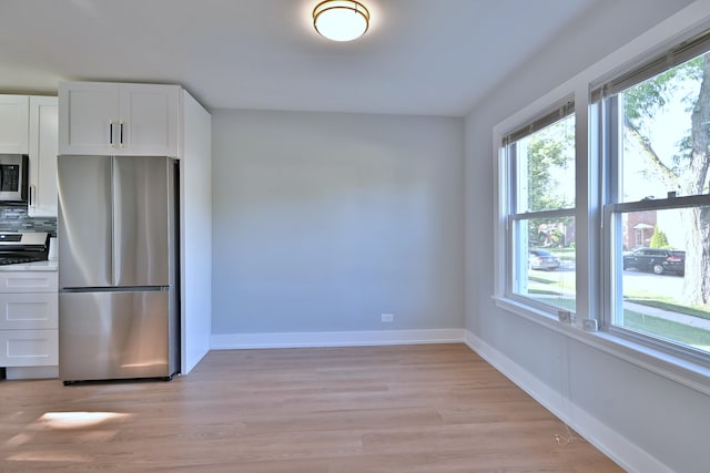 2024 S 24th Ave, Broadview, IL 60155 - kitchen with appliances with stainless steel finishes, white cabinets, light wood-style flooring, and tasteful backsplash