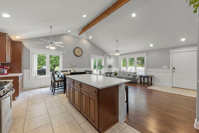 14301 S California Ave, Posen, IL 60469 - kitchen with ceiling fan, a decorative wall, stainless steel gas stove, wainscoting, and light countertops