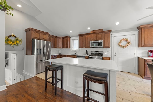 14301 S California Ave, Posen, IL 60469 - kitchen with appliances with stainless steel finishes, tasteful backsplash, a kitchen breakfast bar, light countertops, and lofted ceiling