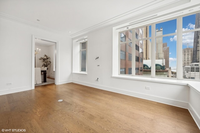 118 E Erie St Unit 19C, Chicago, IL 60611 - spare room with crown molding, a chandelier, wood finished floors, and a view of city