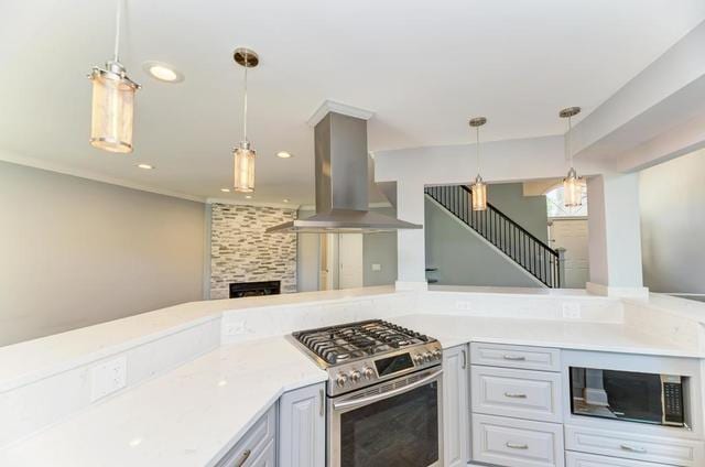 2716 Burton Dr, Westchester, IL 60154 - kitchen with gas range, island exhaust hood, light countertops, pendant lighting, and recessed lighting