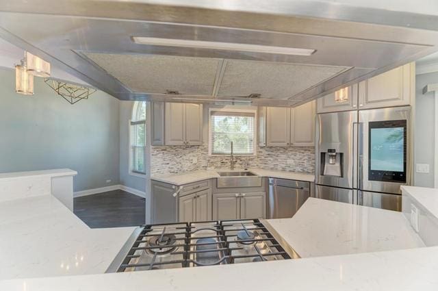 2716 Burton Dr, Westchester, IL 60154 - kitchen featuring appliances with stainless steel finishes, backsplash, wood finished floors, and light stone countertops