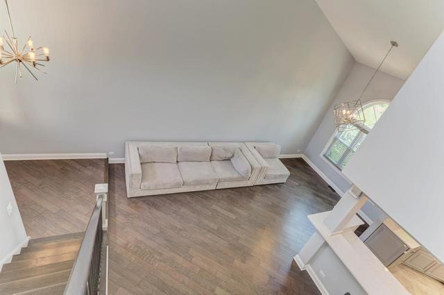 2716 Burton Dr, Westchester, IL 60154 - living area featuring a chandelier, wood finished floors, and vaulted ceiling