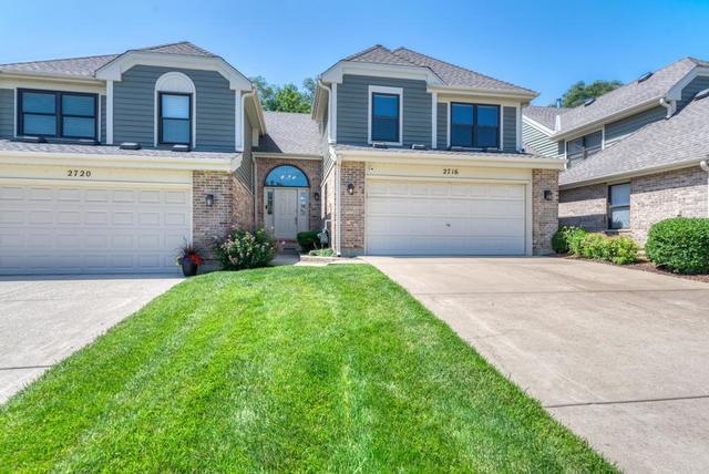 2716 Burton Dr, Westchester, IL 60154 - traditional-style house featuring a garage, concrete driveway, brick siding, and a front lawn