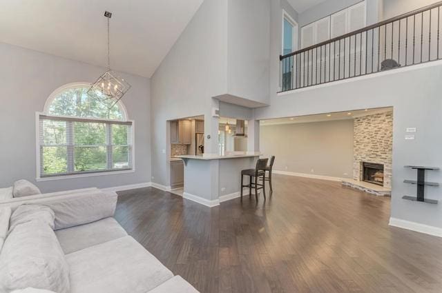 2716 Burton Dr, Westchester, IL 60154 - living area featuring high vaulted ceiling, dark wood finished floors, a chandelier, and a fireplace with raised hearth
