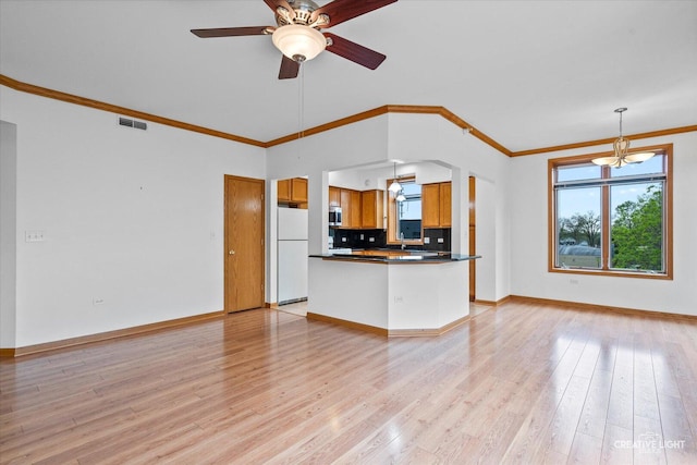 515 Main St Unit 402, West Chicago, IL 60185 - kitchen featuring freestanding refrigerator, brown cabinetry, dark countertops, plenty of natural light, and ornamental molding
