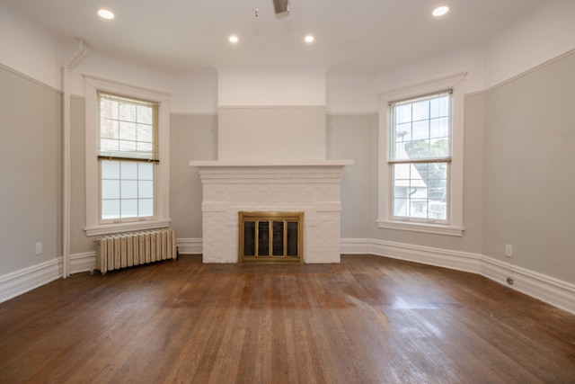 312 Home Ave, Oak Park, IL 60302 - unfurnished living room featuring radiator, plenty of natural light, wood finished floors, a fireplace with flush hearth, and recessed lighting
