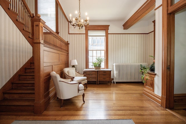 312 Home Ave, Oak Park, IL 60302 - sitting room with radiator heating unit, stairs, wallpapered walls, a chandelier, and wood finished floors