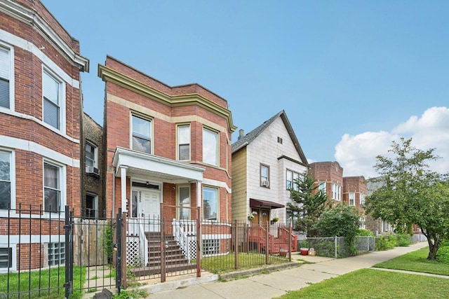 6225 S Wood St, Chicago, IL 60636 - view of front of property featuring a fenced front yard, brick siding, covered porch, a gate, and a residential view