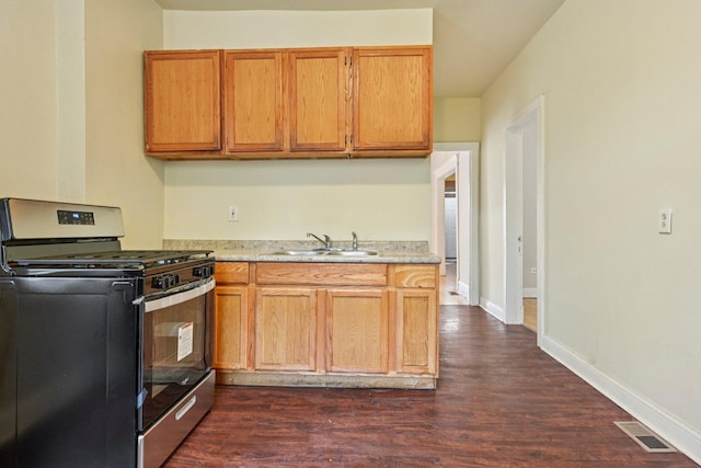 6225 S Wood St, Chicago, IL 60636 - kitchen with gas stove, light countertops, dark wood finished floors, and brown cabinetry