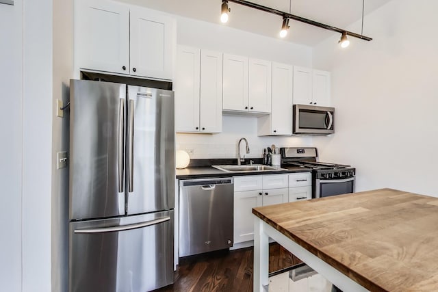 1720 N Marshfield Ave Unit 108, Chicago, IL 60622 - kitchen featuring stainless steel appliances, dark countertops, white cabinets, dark wood-type flooring, and track lighting