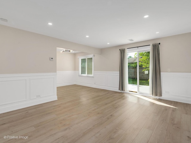 865 W Bryn Mawr Ave, Roselle, IL 60172 - spare room with wainscoting, a chandelier, light wood-style floors, a decorative wall, and recessed lighting