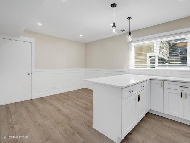 865 W Bryn Mawr Ave, Roselle, IL 60172 - kitchen featuring a wainscoted wall, light wood-type flooring, white cabinets, light countertops, and hanging light fixtures
