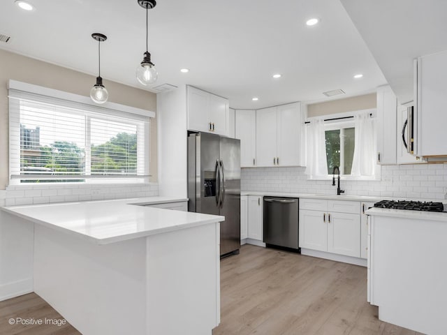 865 W Bryn Mawr Ave, Roselle, IL 60172 - kitchen with appliances with stainless steel finishes, healthy amount of natural light, a peninsula, white cabinetry, and recessed lighting