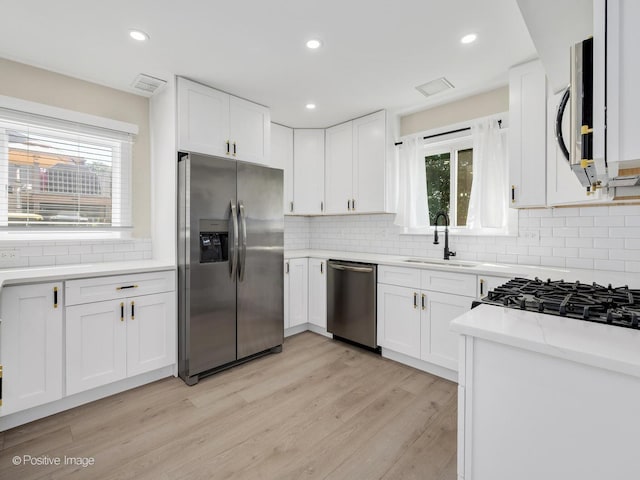 865 W Bryn Mawr Ave, Roselle, IL 60172 - kitchen featuring stainless steel appliances, decorative backsplash, light wood-type flooring, white cabinetry, and recessed lighting
