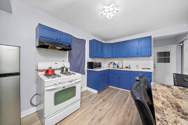 4532 S Laflin St, Chicago, IL 60609 - kitchen with stainless steel appliances, under cabinet range hood, blue cabinets, and light wood-type flooring