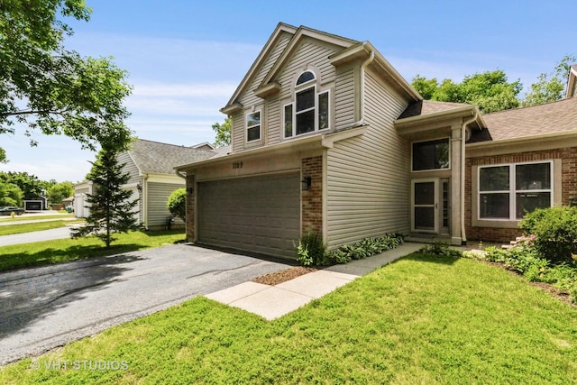 1109 Blackburn Dr, Grayslake, IL 60030 - view of front of house with brick siding, a garage, driveway, and a front lawn