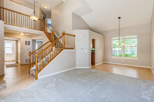 1109 Blackburn Dr, Grayslake, IL 60030 - unfurnished living room featuring tile patterned floors, high vaulted ceiling, a chandelier, stairway, and carpet floors