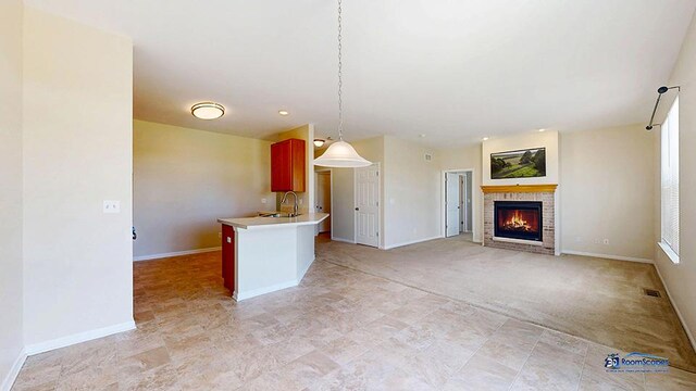2215 Truman Trl, Mchenry, IL 60051 - kitchen featuring a brick fireplace, a peninsula, decorative light fixtures, light countertops, and open floor plan