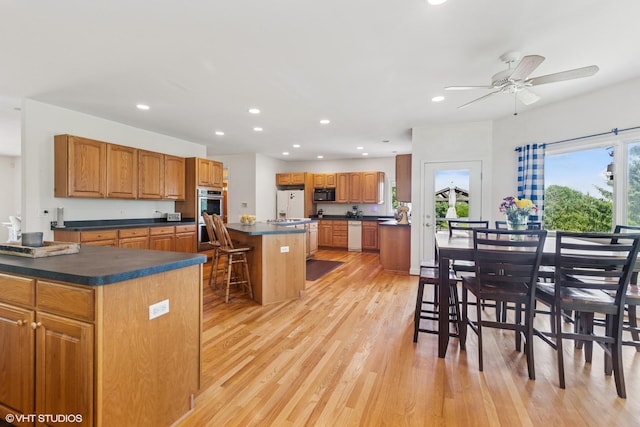 26 Red Hawk Dr, Oswego, IL 60543 - kitchen with black microwave, dark countertops, a kitchen island, light wood-type flooring, and recessed lighting