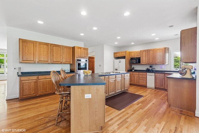 26 Red Hawk Dr, Oswego, IL 60543 - kitchen featuring white appliances, a kitchen island, dark countertops, healthy amount of natural light, and recessed lighting