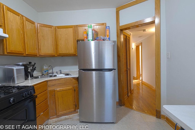 5942 S Calumet Ave, Chicago, IL 60637 - kitchen featuring freestanding refrigerator, black gas range, light countertops, ventilation hood, and light flooring