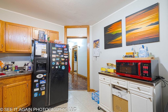 5942 S Calumet Ave, Chicago, IL 60637 - kitchen with black refrigerator with ice dispenser, dark countertops, crown molding, and light floors