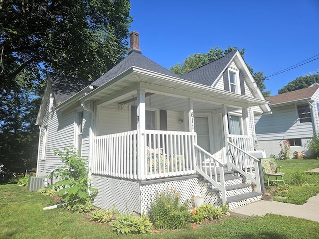 611 S Dixon Ave, Dixon, IL 61021 - bungalow featuring covered porch, a shingled roof, a chimney, and a front lawn