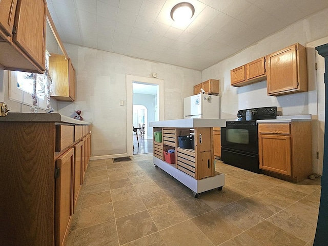 611 S Dixon Ave, Dixon, IL 61021 - kitchen with black electric range, white fridge, brown cabinets, and light countertops