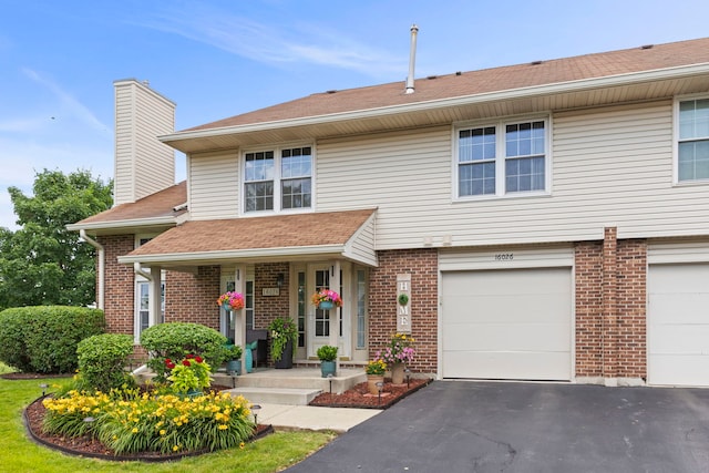 16026 85th Pl, Tinley Park, IL 60487 - view of front facade featuring driveway, brick siding, an attached garage, and a chimney